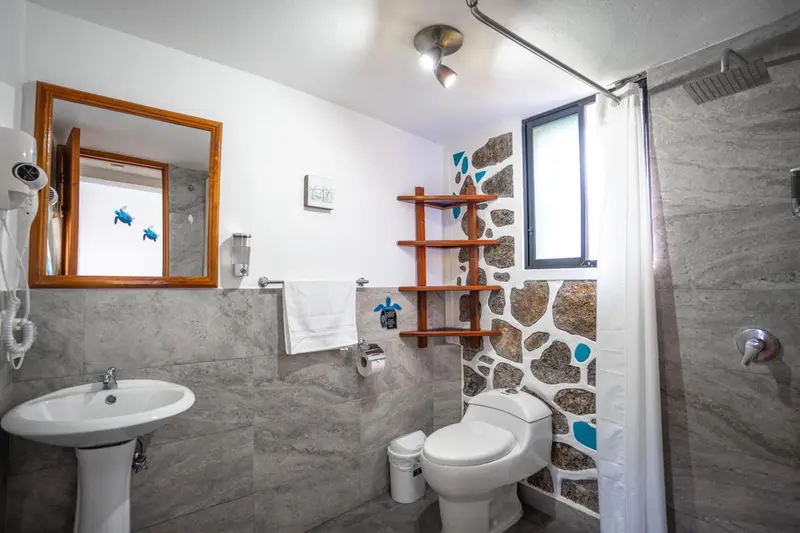 Une salle de bain claire avec douche et lavabo.