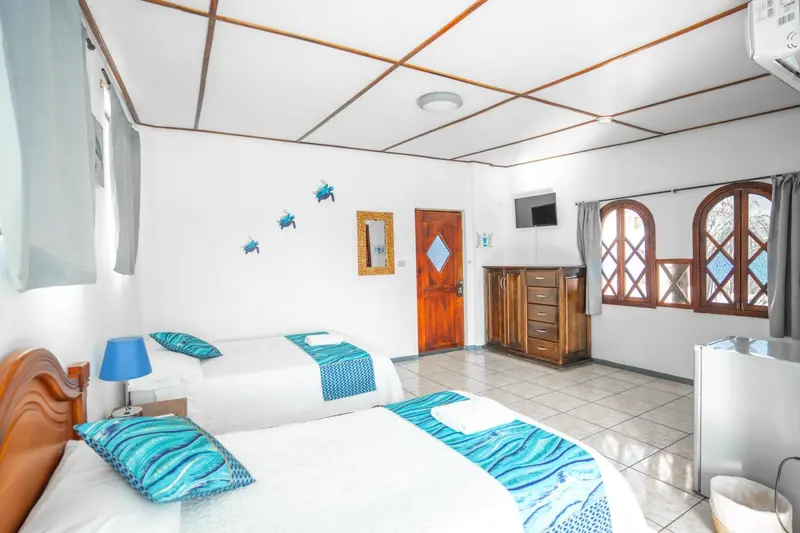 Chambre lumineuse avec deux lits simples et une décoration marine.