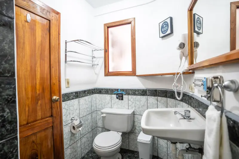 Une salle de bain lumineuse avec des carreaux et des accessoires.