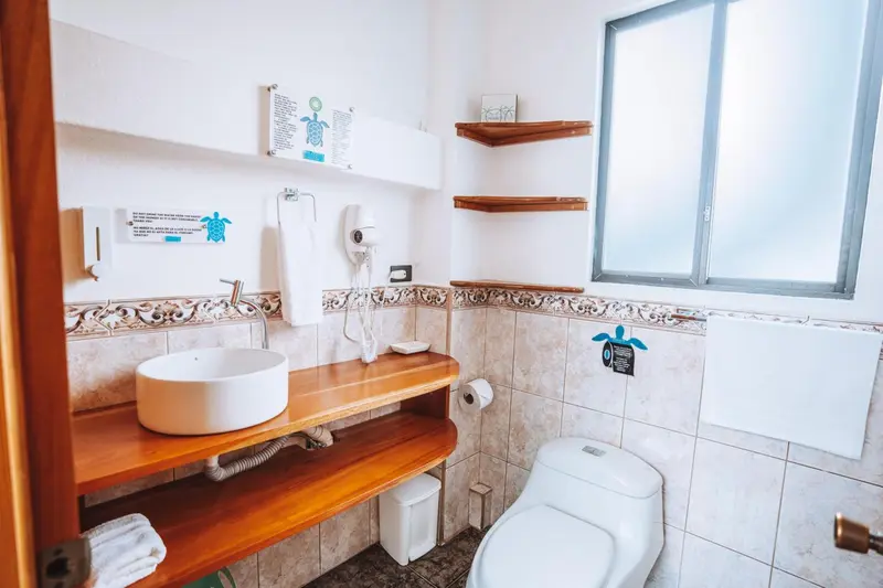 Une salle de bain lumineuse avec lavabo, miroir et toilettes.