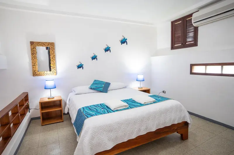 Une chambre lumineuse avec un lit double et des décorations murales.
