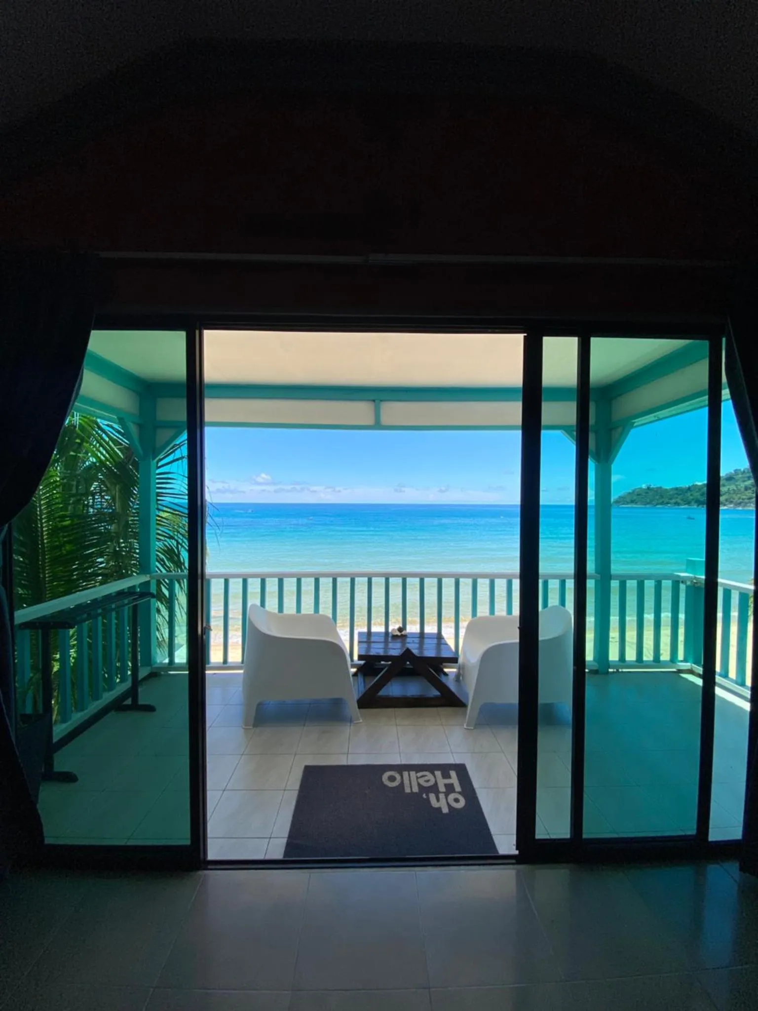 Vue sur la mer depuis une terrasse avec deux fauteuils et une table basse.