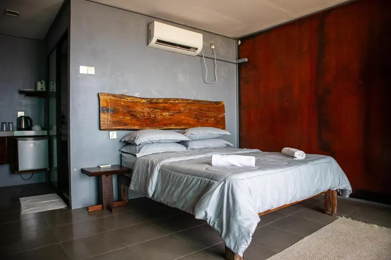Une chambre avec un grand lit et une tête de lit en bois.