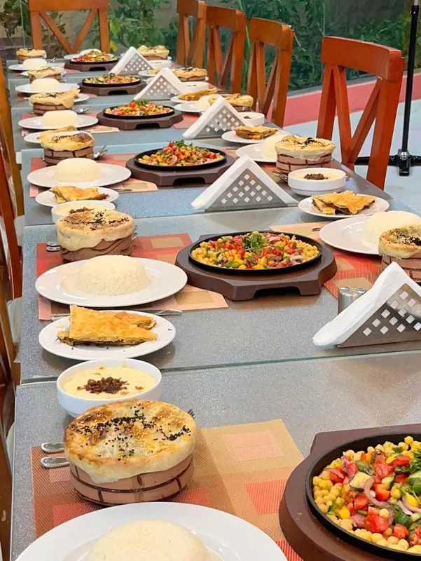 Une longue table est dressée avec de nombreux plats variés.