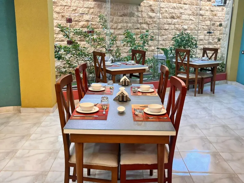 Une salle de restaurant avec des tables dressées pour le service.