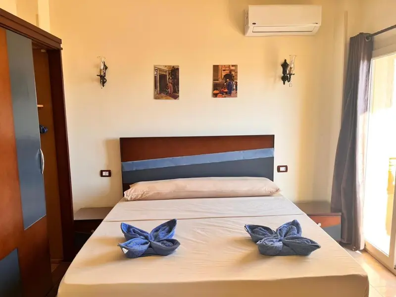 Une chambre lumineuse avec un grand lit et des décorations florales en serviettes.