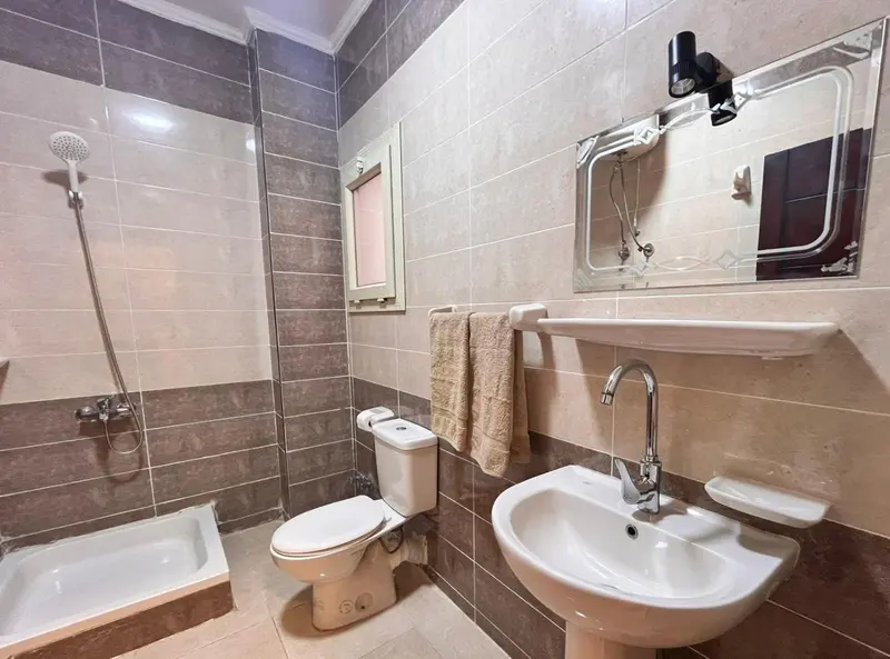 Une salle de bain claire avec douche, baignoire et lavabo.