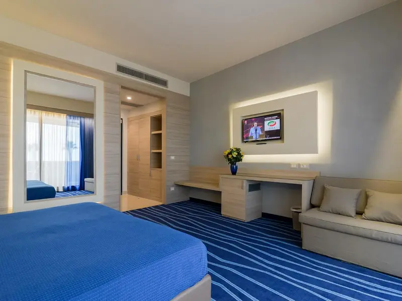 Chambre moderne avec un grand lit et un espace détente.
