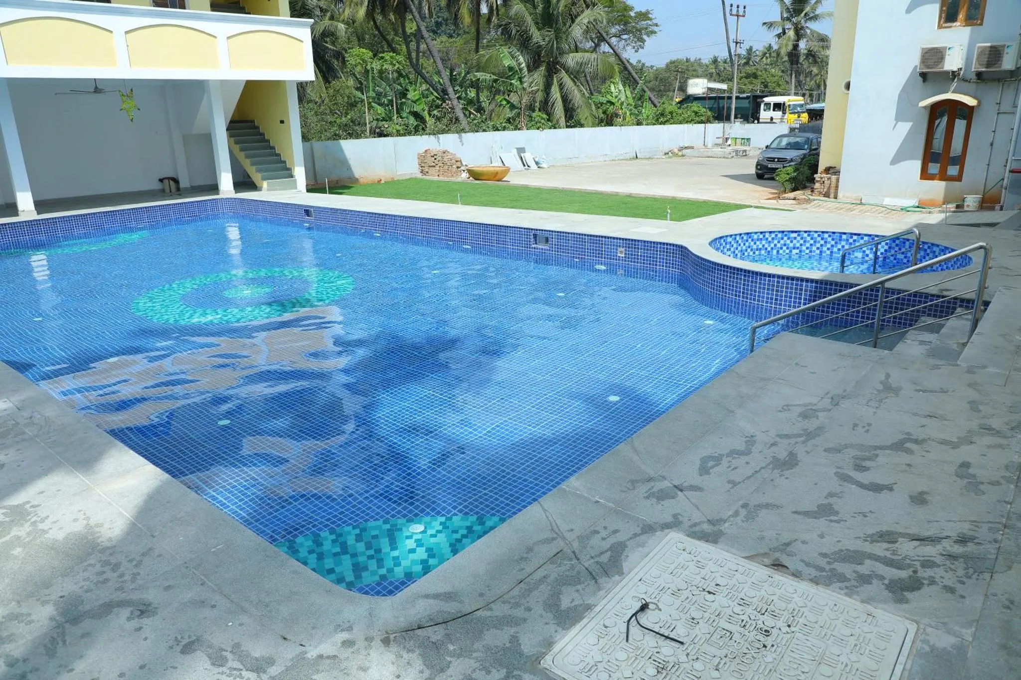 Une piscine rectangulaire bleu clair avec un espace de détente ensoleillé.