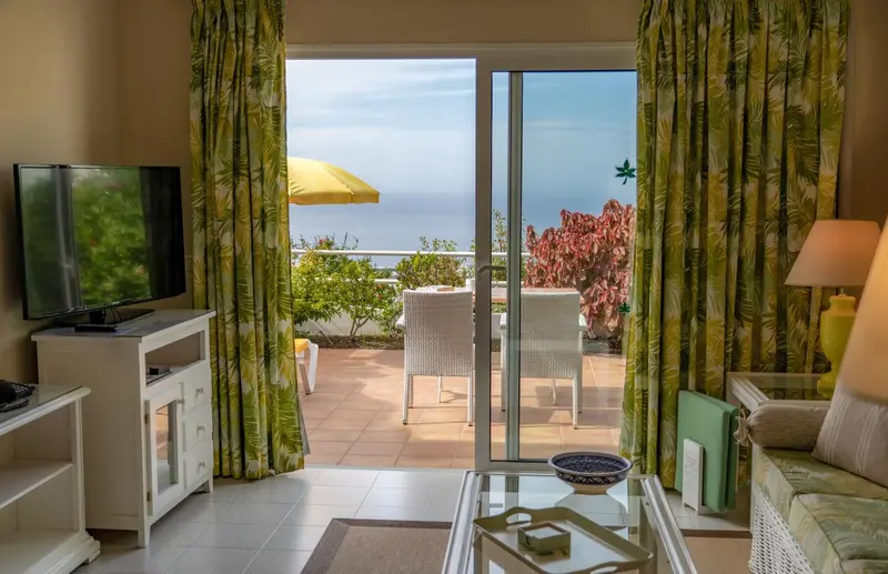 Un salon lumineux s'ouvre sur une terrasse avec vue sur la mer.