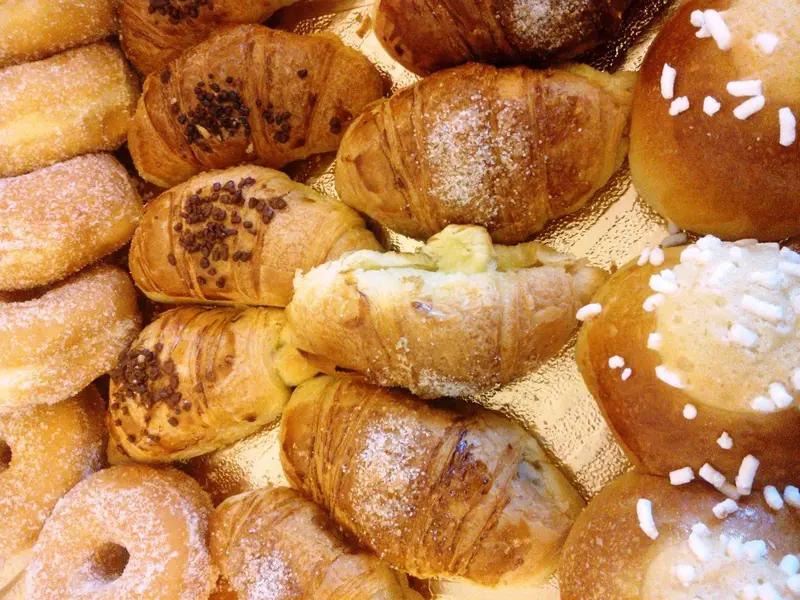Assortiment de viennoiseries dorées sur une plaque.