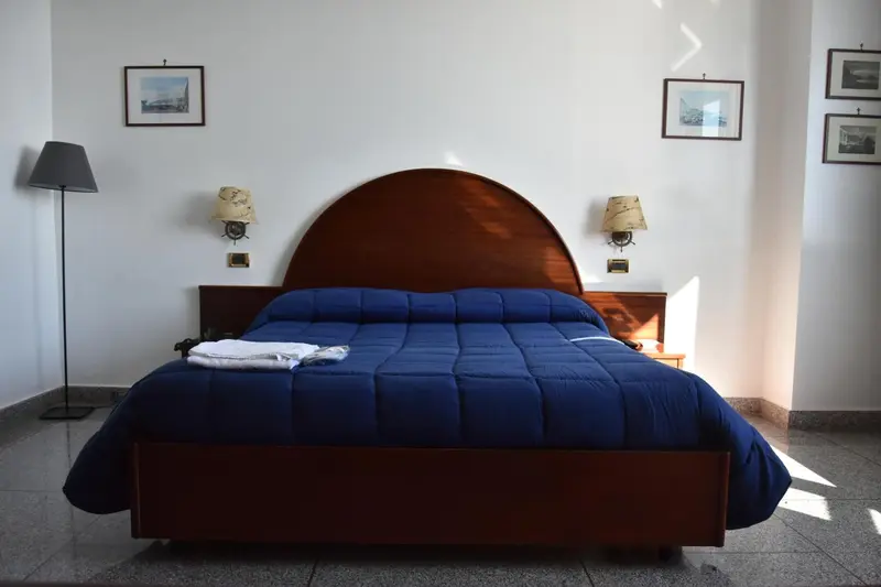 Une chambre avec un grand lit recouvert d'une couette bleue.