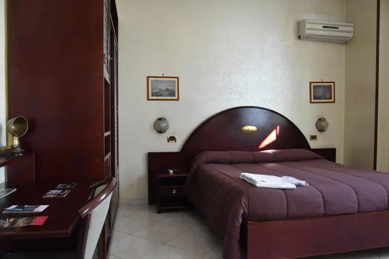 Une chambre avec un grand lit et des tableaux décoratifs.