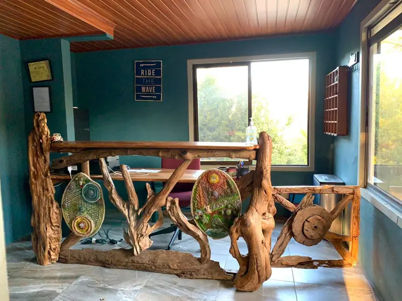 Une table en bois rustique est entourée de chaises dans une pièce aux murs turquoise.