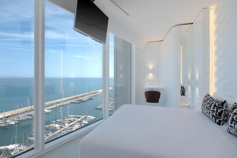 Chambre lumineuse avec vue sur un port de plaisance.