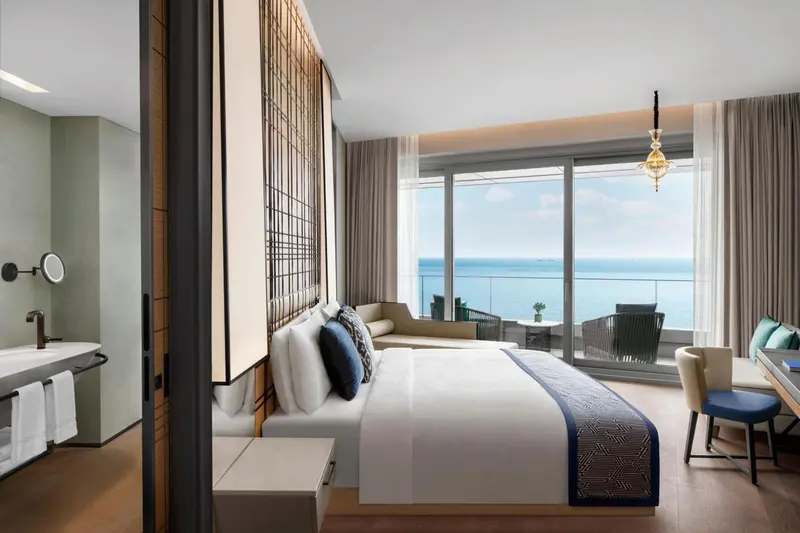 Une chambre lumineuse avec un grand lit et une vue sur la mer.