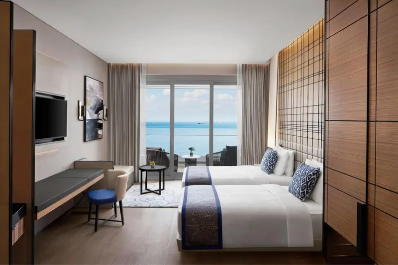 Chambre lumineuse avec vue sur la mer et balcon aménagé.