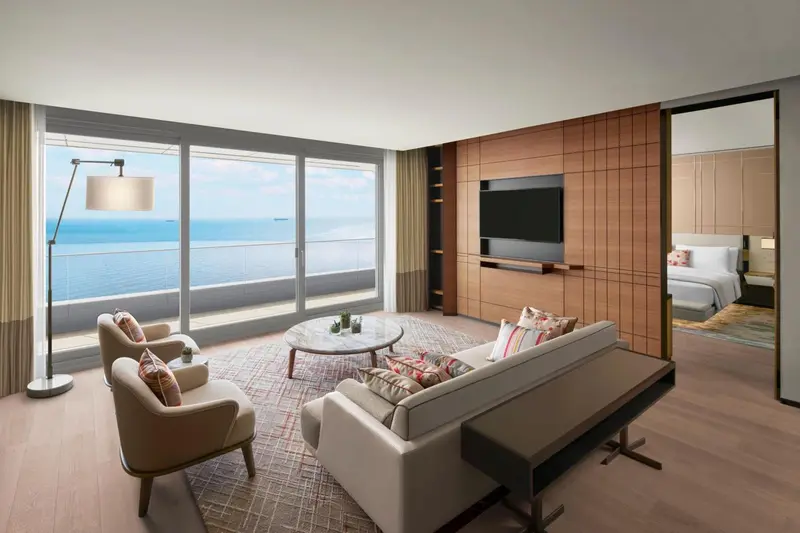 Espace de détente lumineux avec canapés et vue sur la mer.