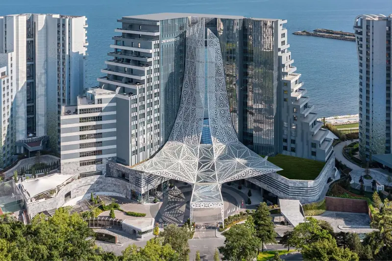 Vue aérienne d'un complexe hôtelier moderne avec une structure architecturale distinctive.