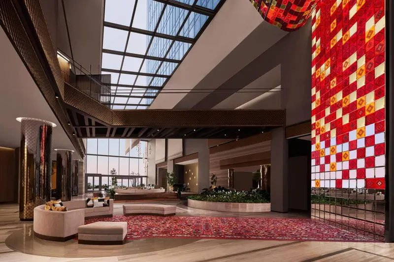 Vaste hall d'accueil avec un mur décoratif et un éclairage zénithal.