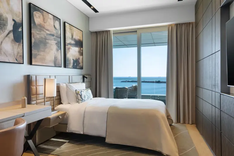 Une chambre lumineuse avec un grand lit et une vue sur la mer.