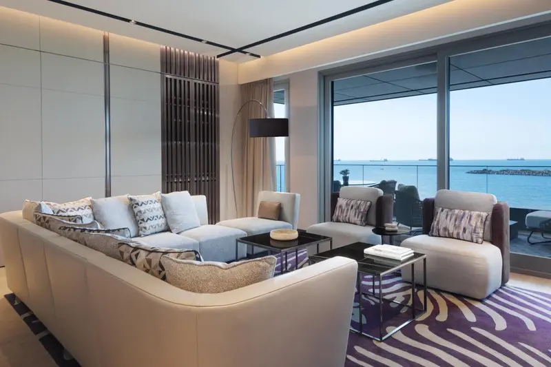 Un salon moderne avec canapés et vue sur la mer.
