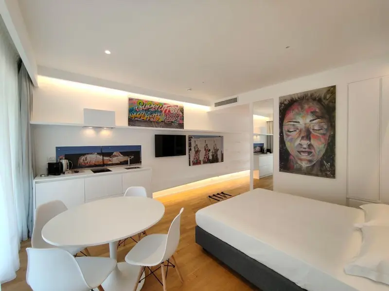 Une chambre lumineuse avec un coin repas et un grand lit.