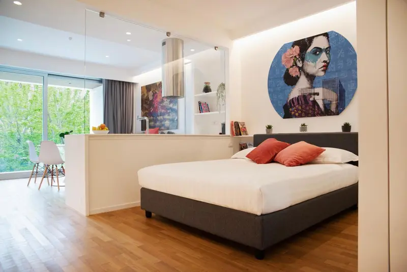 Une chambre lumineuse avec un lit et un coin repas.