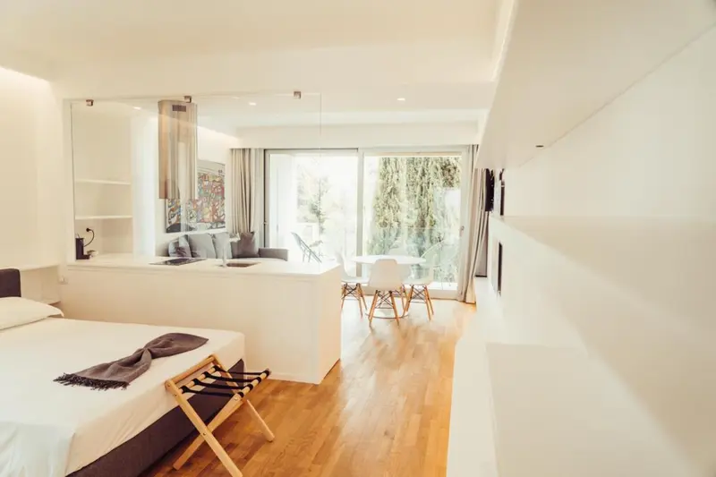 Une chambre lumineuse avec un coin repas et un lit recouvert d'une couverture.