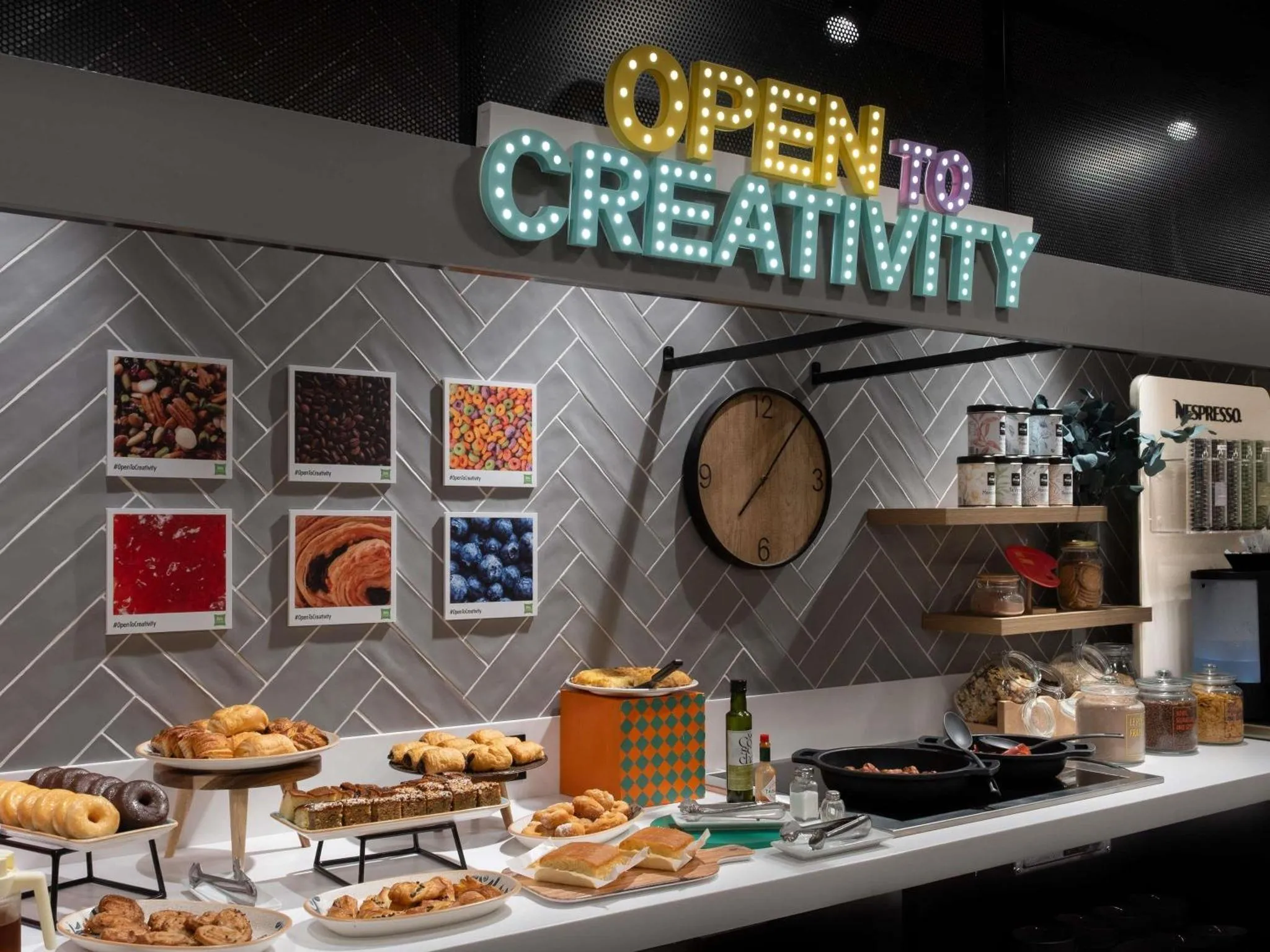 Un comptoir de buffet propose des viennoiseries et des boissons chaudes dans un espace lumineux.