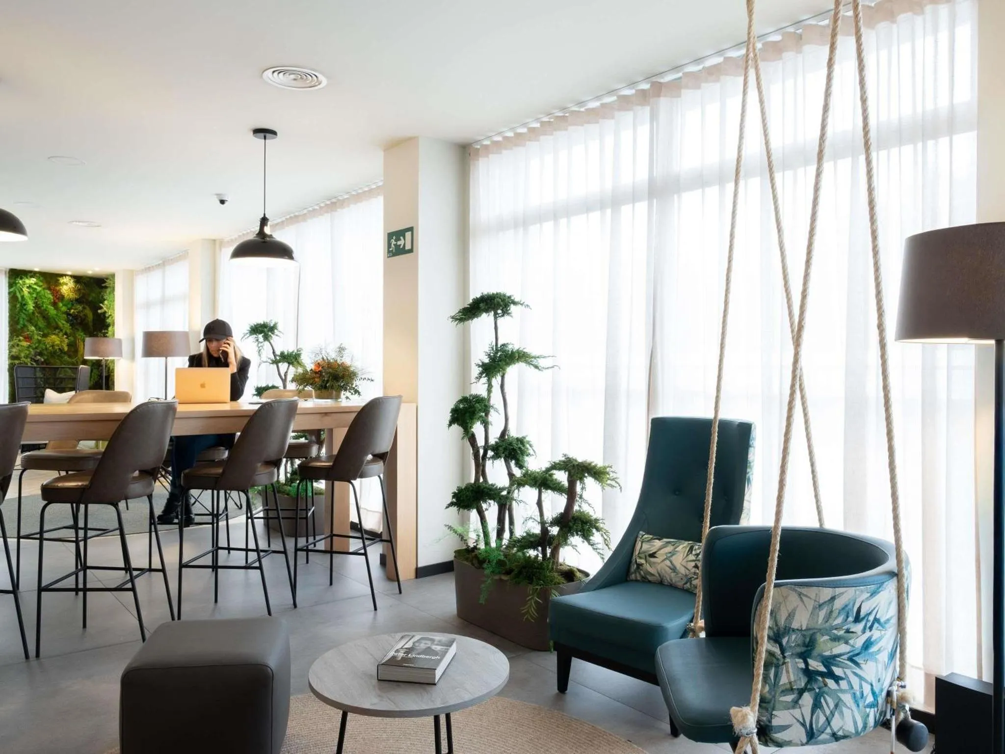 Espace de détente intérieur avec fauteuils et plantes.