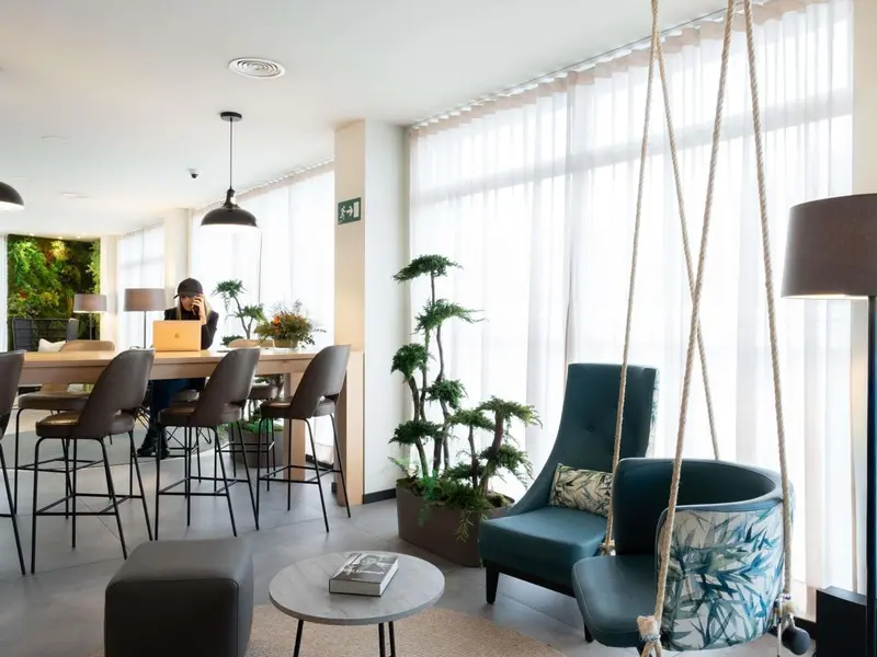 Espace de détente intérieur avec fauteuils et plantes.