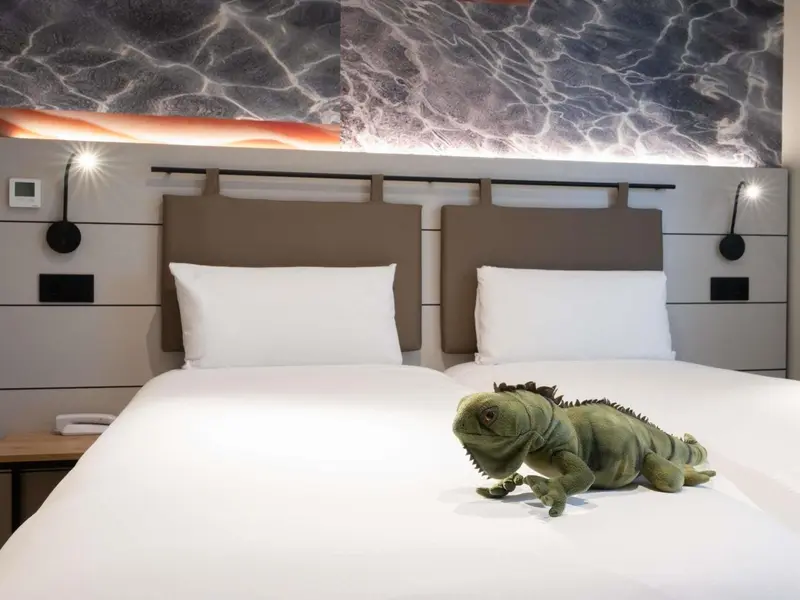 Une chambre avec un lit double et une décoration murale abstraite.