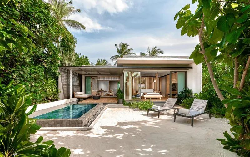 Villa avec piscine privée et mobilier de jardin.