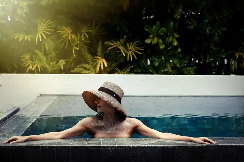 Une personne se relaxe dans une piscine extérieure.