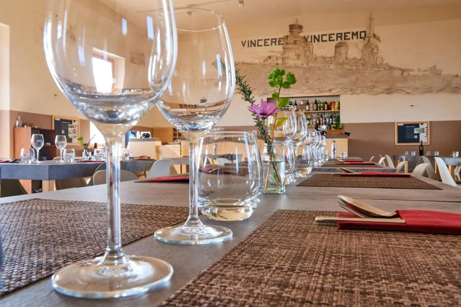 Une table dressée avec des verres et des couverts dans une salle à manger.