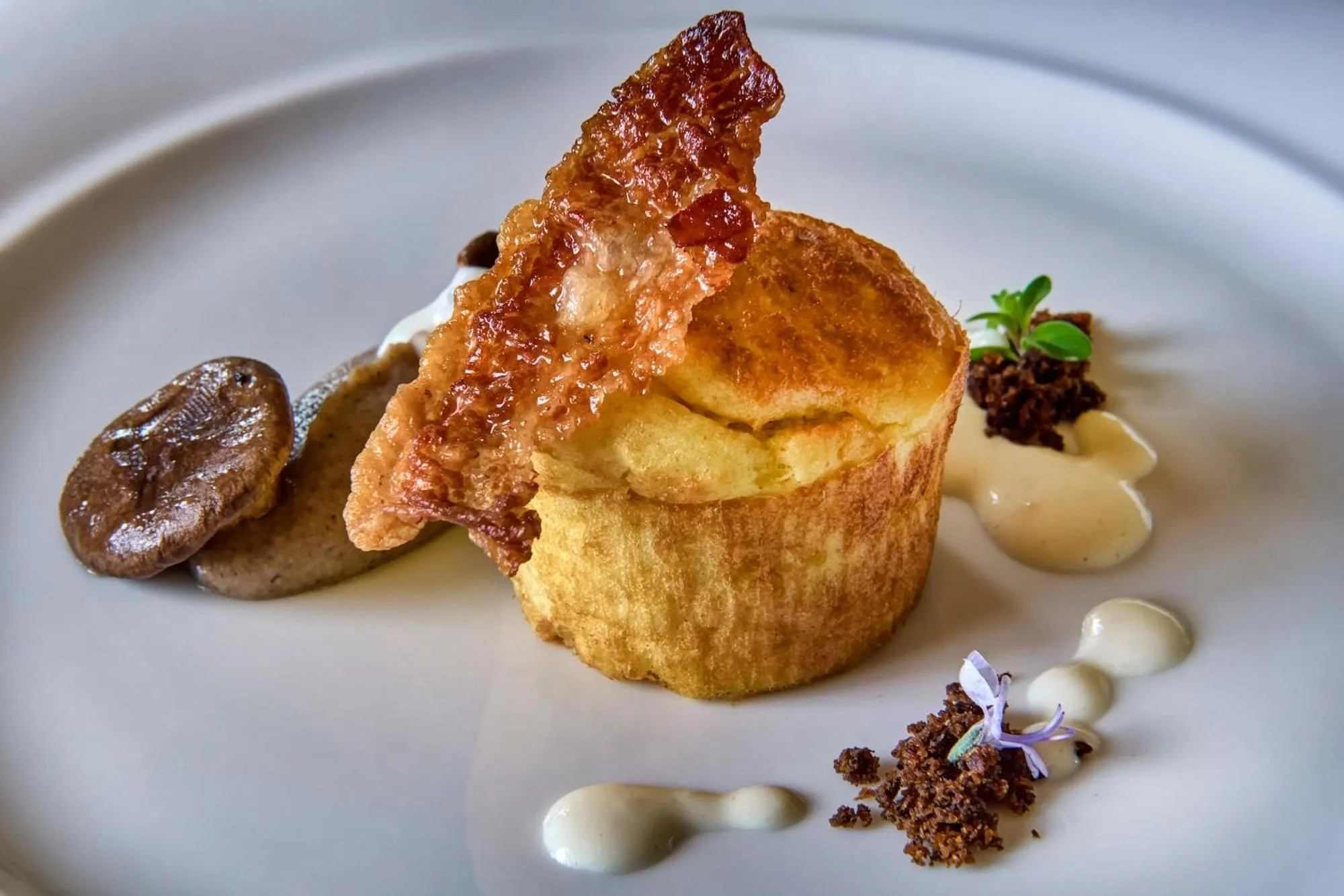 Présentation gastronomique d'un plat raffiné avec une texture croustillante et des éléments décoratifs.
