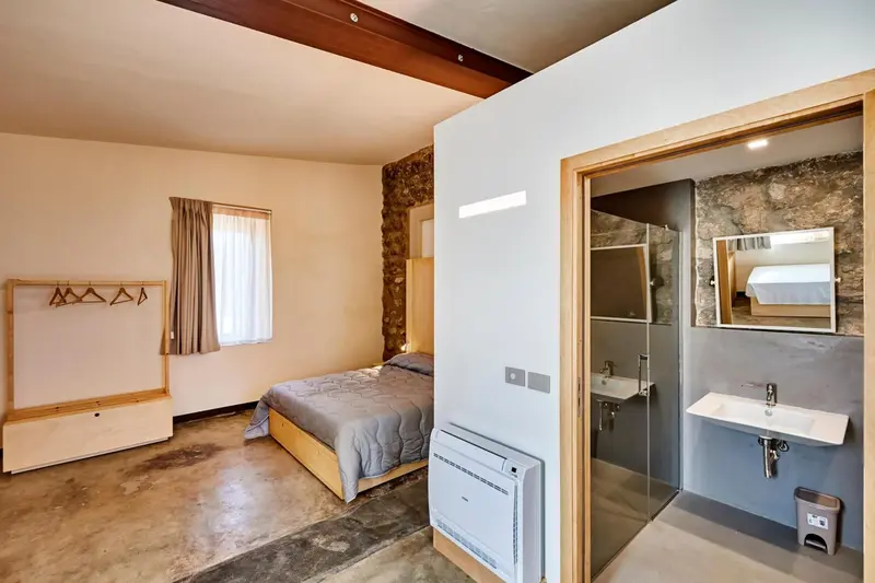 Une chambre lumineuse avec un lit et un accès à une salle de bain.
