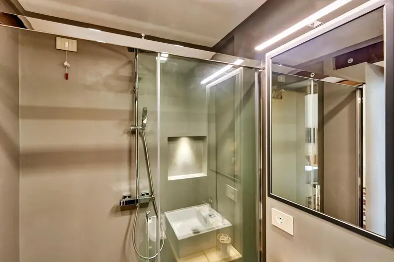 Douche à l'italienne avec parois vitrées et éclairage intégré.