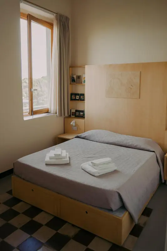 Une chambre lumineuse avec un lit simple et une fenêtre.