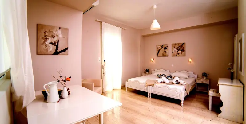 Une chambre lumineuse avec un lit double et une décoration florale.
