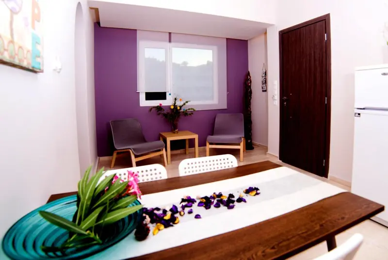 Un espace de détente avec deux fauteuils et une table basse devant un buffet décoré de fleurs.