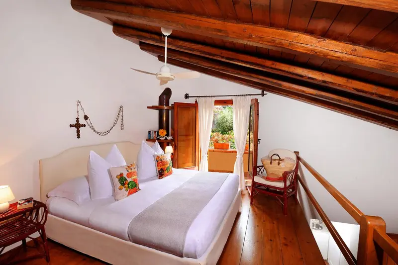 Une chambre lumineuse avec un lit recouvert de blanc et une décoration florale.