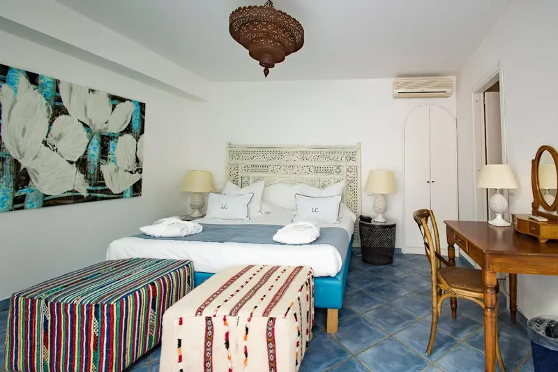 Une chambre lumineuse avec un grand lit et une décoration colorée.