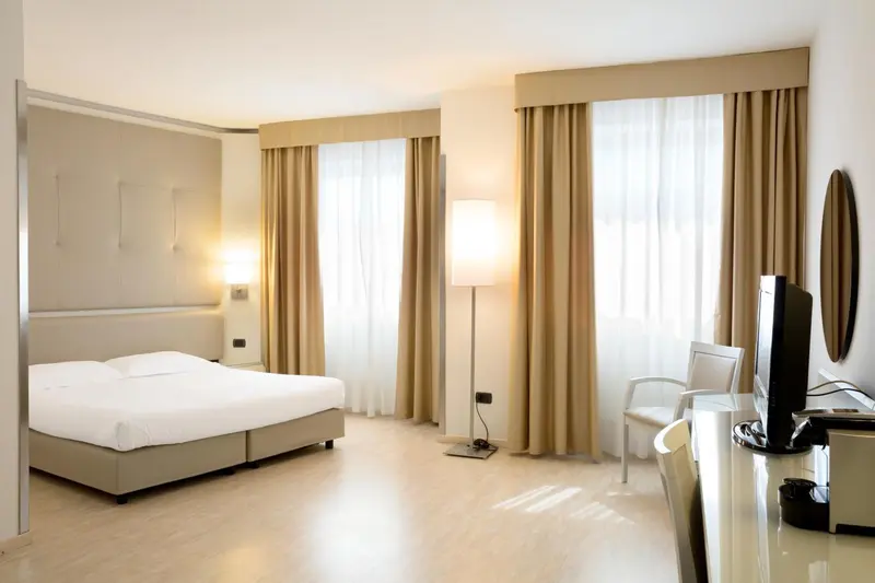 Une chambre lumineuse avec un grand lit et un bureau.