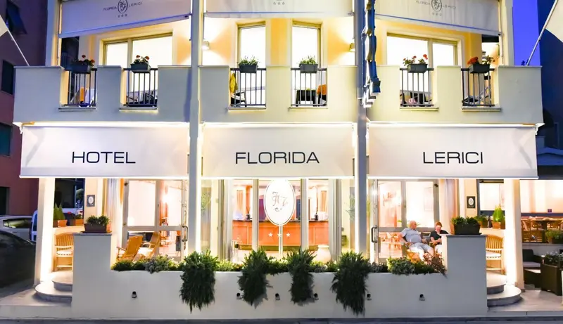 Façade d'un hôtel illuminée avec des plantes en pot.