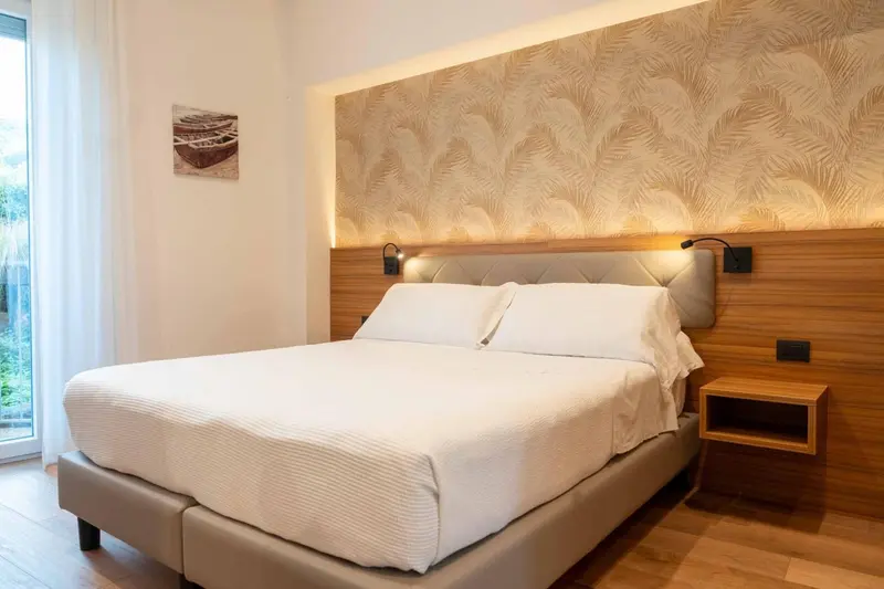 Une chambre lumineuse avec un grand lit et un mur texturé.