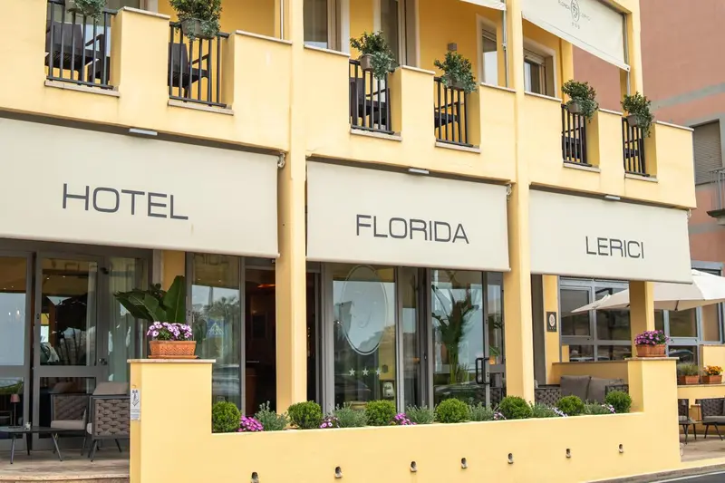 Façade jaune d'un bâtiment avec des balcons et des stores.