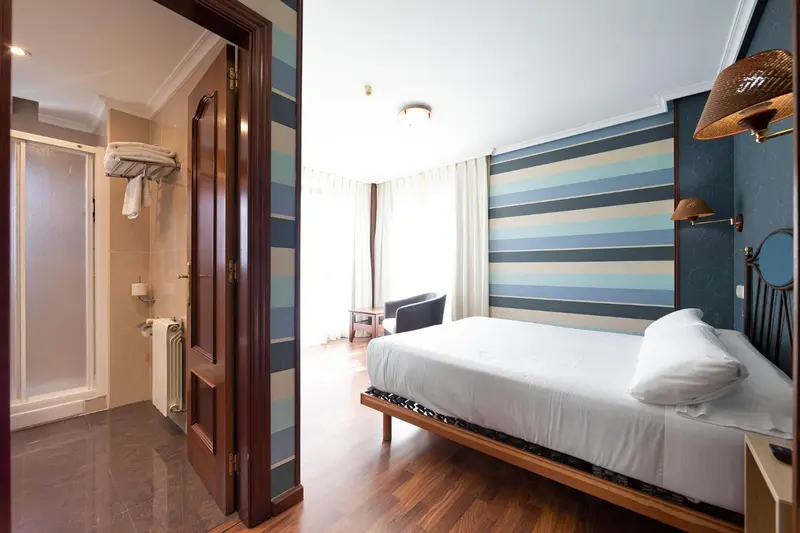Une chambre lumineuse avec un lit simple et une salle de bain attenante.