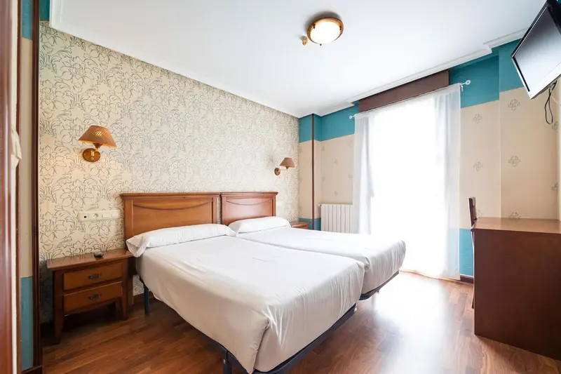 Une chambre lumineuse avec un lit double et une décoration florale.